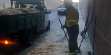 Bomberos de Peñaranda limpian el paso inferior de la carretera de Alba para retirar la paja caída de un camión y reabrirlo al tráfico