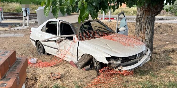 Espectacular accidente de un vehículo junto a la estación de Babilafuente tras impactar contra el muro y quedar junto a un árbol