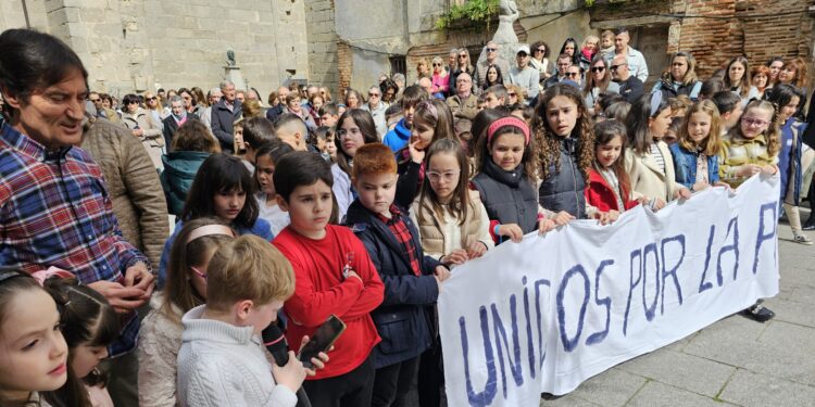 La parroquia de Peñaranda realiza una oración por la paz que reúne a niños y mayores en la plaza de Agustín Martínez Soler