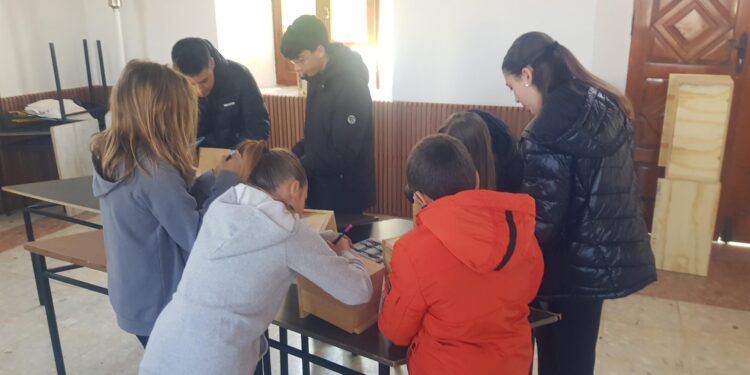Niños y niñas de Rágama participan en un taller para decorar las cajas nido que se instalarán en varias zonas de la localidad