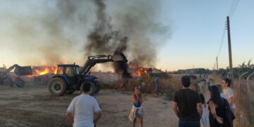 Bomberos y vecinos de Bóveda del Río Almar trabajan en la extinción de un gran incendio en una granja de vacuno de leche