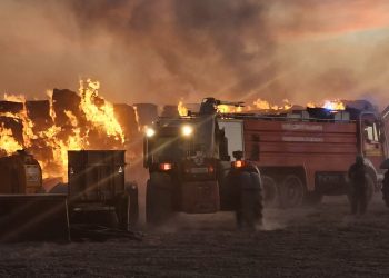 Bomberos y vecinos de Bóveda del Río Almar trabajan en la extinción de un gran incendio en una granja de vacuno de leche