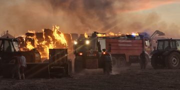 Bomberos y vecinos de Bóveda del Río Almar trabajan en la extinción de un gran incendio en una granja de vacuno de leche